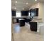 Modern kitchen boasts dark cabinetry, stainless steel appliances, and granite countertops at 4224 Sagefield Dr, Harmony, FL 34773