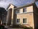 Corner of a two-story condo building with a stucco exterior, tile roof, and neatly trimmed shrubs at 495 Las Cortes Ln # 206, Orlando, FL 32824