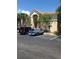 Tan condo building featuring a tile roof, palm trees, and parking in front at 495 Las Cortes Ln # 206, Orlando, FL 32824