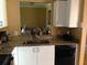Kitchen showcasing a breakfast bar, granite countertops, white cabinets and black appliances at 495 Las Cortes Ln # 206, Orlando, FL 32824