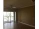 Empty living room featuring wood floors, neutral-toned walls, and a sliding glass door at 495 Las Cortes Ln # 206, Orlando, FL 32824