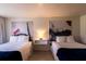 Bright hotel room with two beds, white linens, unique artwork, and hardwood floors at 5245 W Irlo Bronson Memorial Hwy # 151, Kissimmee, FL 34746