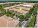 An aerial view shows townhomes with tile roofs, mature trees, parking, and manicured landscaping at 724 Greybull Run, Lake Mary, FL 32746