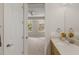 Bright bathroom featuring a vanity with a sleek countertop, a decorative mirror, and access to the carpeted bedroom at 724 Greybull Run, Lake Mary, FL 32746