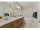 Elegant bathroom featuring double sinks, wood cabinets, a large mirror, tub, and shower at 724 Greybull Run, Lake Mary, FL 32746