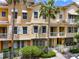 Charming townhome exterior with lush landscaping, palm trees, shutters, and white picket fence offers curb appeal at 724 Greybull Run, Lake Mary, FL 32746