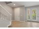 Bright foyer boasts neutral walls, tile floors, white staircase and a glass-paneled door at 724 Greybull Run, Lake Mary, FL 32746