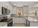 Well-lit kitchen boasting stainless steel appliances, granite countertops, and white cabinets, perfect for culinary enthusiasts at 724 Greybull Run, Lake Mary, FL 32746