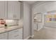 Elegant kitchen area with white cabinetry, granite countertops, undermount lighting and views to living area at 724 Greybull Run, Lake Mary, FL 32746