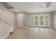Bright living room featuring tile floors, staircase, and double doors leading to a balcony at 724 Greybull Run, Lake Mary, FL 32746