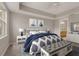 Serene bedroom featuring tray ceilings, a comfortable bed, a bench and access to the ensuite bathroom at 724 Greybull Run, Lake Mary, FL 32746