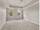 Bright main bedroom features tray ceiling, neutral carpet and two windows at 724 Greybull Run, Lake Mary, FL 32746