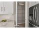 Convenient walk-in pantry with wire shelving, situated next to the stainless steel refrigerator and white cabinets at 724 Greybull Run, Lake Mary, FL 32746