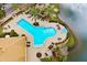Aerial view of a large pool and hot tub area with lounge chairs, landscaping, and lake view at 724 Greybull Run, Lake Mary, FL 32746