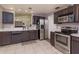 Functional kitchen with stainless steel appliances, dark wood cabinets, and a pass-through to another room at 1023 Royal Oaks Dr, Apopka, FL 32703