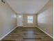 Inviting living room with wood-look flooring, neutral walls, and a front door at 1084 Doyle Rd, Deltona, FL 32725