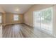 Bright living room with neutral walls, wood-look flooring, and sliding glass doors to the backyard at 1084 Doyle Rd, Deltona, FL 32725