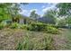 View of the home's backyard with a screened-in pool and lush greenery at 1100 Oday Dr, Winter Springs, FL 32708