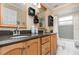 This bathroom boasts double sinks, granite countertops, wooden cabinets, and a tiled shower-tub at 1100 Oday Dr, Winter Springs, FL 32708