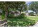 Landscaped front yard featuring mature trees with a peek at the house and two-car garage at 1100 Oday Dr, Winter Springs, FL 32708