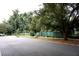 A quiet street with a green wooden fence providing privacy and enhancing the curb appeal of the adjacent property at 1100 Oday Dr, Winter Springs, FL 32708