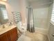 Well-lit bathroom featuring a bathtub and shower combination, complementing the tiled flooring and vanity sink at 11742 Chateaubriand Ave, Orlando, FL 32836