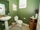 Charming powder room with green walls, pedestal sink, and decorative accents at 11742 Chateaubriand Ave, Orlando, FL 32836