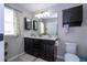 Bathroom featuring double sinks in a vanity with a framed mirror and a toilet at 11957 Vermillion Ave, Windermere, FL 34786