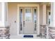 Charming front entryway with decorative door, sidelights and stone-accented porch columns at 11957 Vermillion Ave, Windermere, FL 34786