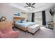 Comfortable main bedroom featuring a decorative tray ceiling, ceiling fan and a window at 11957 Vermillion Ave, Windermere, FL 34786