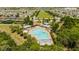 Aerial view of community pool featuring lounge chairs, splashpad, restrooms, playground, and beautiful landscaping at 11957 Vermillion Ave, Windermere, FL 34786