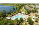 Aerial view of a community pool next to a lake with a splash pad and playground at 11957 Vermillion Ave, Windermere, FL 34786