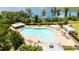 Aerial view of community pool featuring lounge chairs, splashpad, restrooms, and beautiful lake view at 11957 Vermillion Ave, Windermere, FL 34786