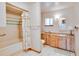 Well-maintained bathroom featuring a shower-tub combo, wood vanity, and patterned wallpaper at 12454 S Lake Mary Jane Rd, Orlando, FL 32832