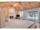 Spacious living room with vaulted wood ceilings, stone fireplace, and access to the outdoor pool area at 12454 S Lake Mary Jane Rd, Orlando, FL 32832