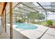 Screened pool features a lush, landscaped yard, covered patio, and lake views at 12454 S Lake Mary Jane Rd, Orlando, FL 32832