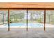 Screened-in pool area boasting clear blue water, lush greenery, and scenic views of the lake at 12454 S Lake Mary Jane Rd, Orlando, FL 32832