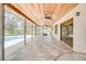 Expansive lanai features a wood ceiling, tiled floors, and views of the screened pool area at 12454 S Lake Mary Jane Rd, Orlando, FL 32832