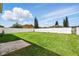 Expansive backyard featuring a lush green lawn, tall trees, and a white fence for privacy at 13054 Prairie Meadows Dr, Orlando, FL 32837