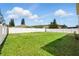 Large backyard with vibrant green grass enclosed by a white fence, perfect for outdoor activities and privacy at 13054 Prairie Meadows Dr, Orlando, FL 32837