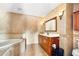 The bathroom features a wooden vanity with light tiled walls and floors at 13054 Prairie Meadows Dr, Orlando, FL 32837