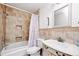 Well-lit bathroom features a shower-tub combo with tiled walls and a classic vanity with a large sink at 13054 Prairie Meadows Dr, Orlando, FL 32837