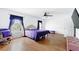Bedroom with hardwood floors, ceiling fan, purple accents, and natural light at 13054 Prairie Meadows Dr, Orlando, FL 32837