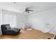 Bedroom/bedroom featuring a ceiling fan, a crib and a soft grey chair with hard wood flooring at 13054 Prairie Meadows Dr, Orlando, FL 32837