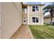 Rear exterior showcasing a walkway, access door, and manicured lawn next to the home at 13054 Prairie Meadows Dr, Orlando, FL 32837