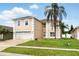 Charming two-story home featuring a manicured lawn, brick driveway, and well-maintained landscaping at 13054 Prairie Meadows Dr, Orlando, FL 32837