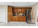 Classic kitchen with stainless steel refrigerator, wooden cabinets, and white tile flooring at 13054 Prairie Meadows Dr, Orlando, FL 32837