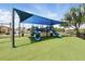 Community playground with blue sunshade features fun slides and climbing areas for outdoor enjoyment at 13054 Prairie Meadows Dr, Orlando, FL 32837