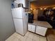 View of the kitchen featuring white refrigerator and cabinets, tile floors and access to the living room at 131 Water Front Way # 200, Altamonte Springs, FL 32701
