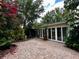 Outdoor patio area with large sliding glass doors, surrounded by colorful foliage at 1399 Aloma Ave, Winter Park, FL 32789